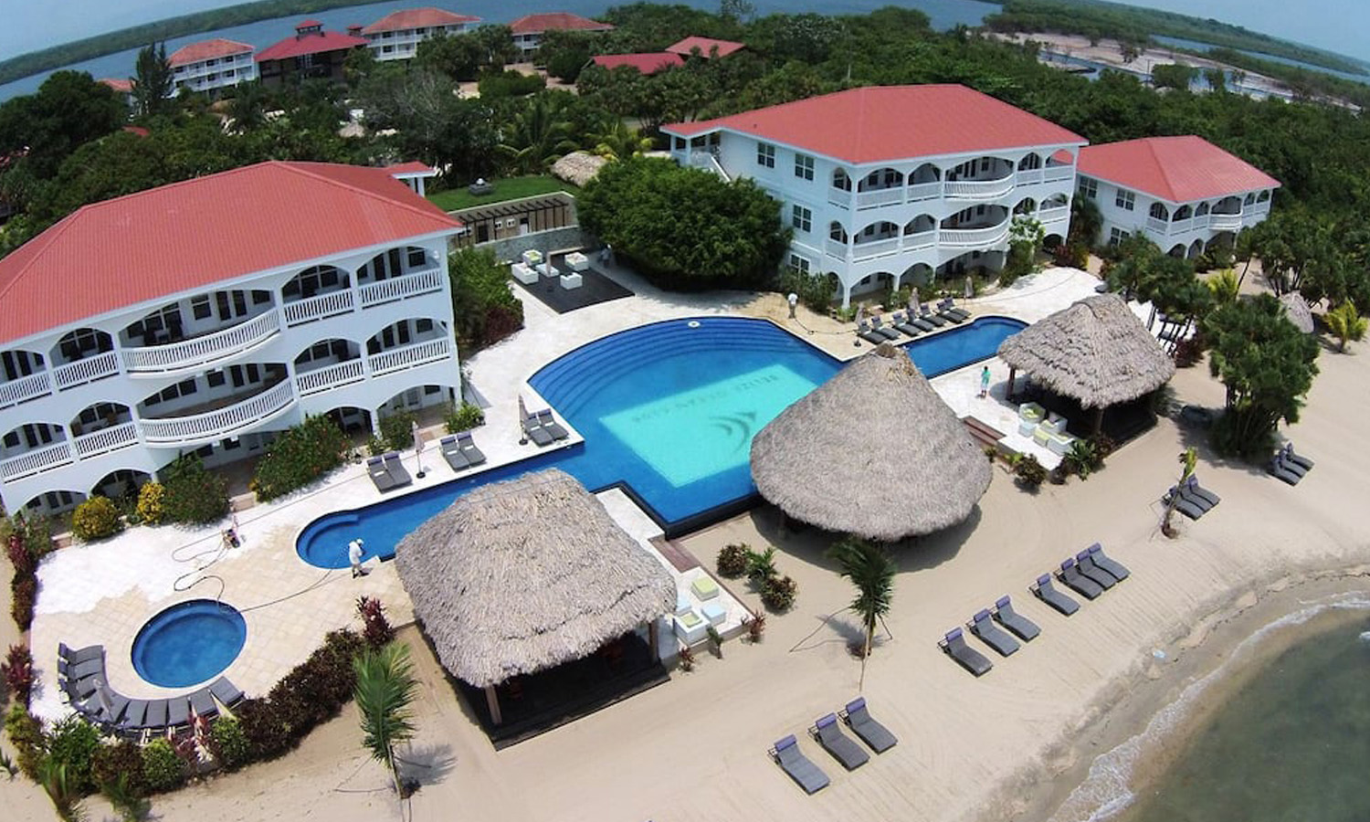 Apartments in Belize for sale and rent. Aerial view of Umaya resort's pool and beachfront bar.